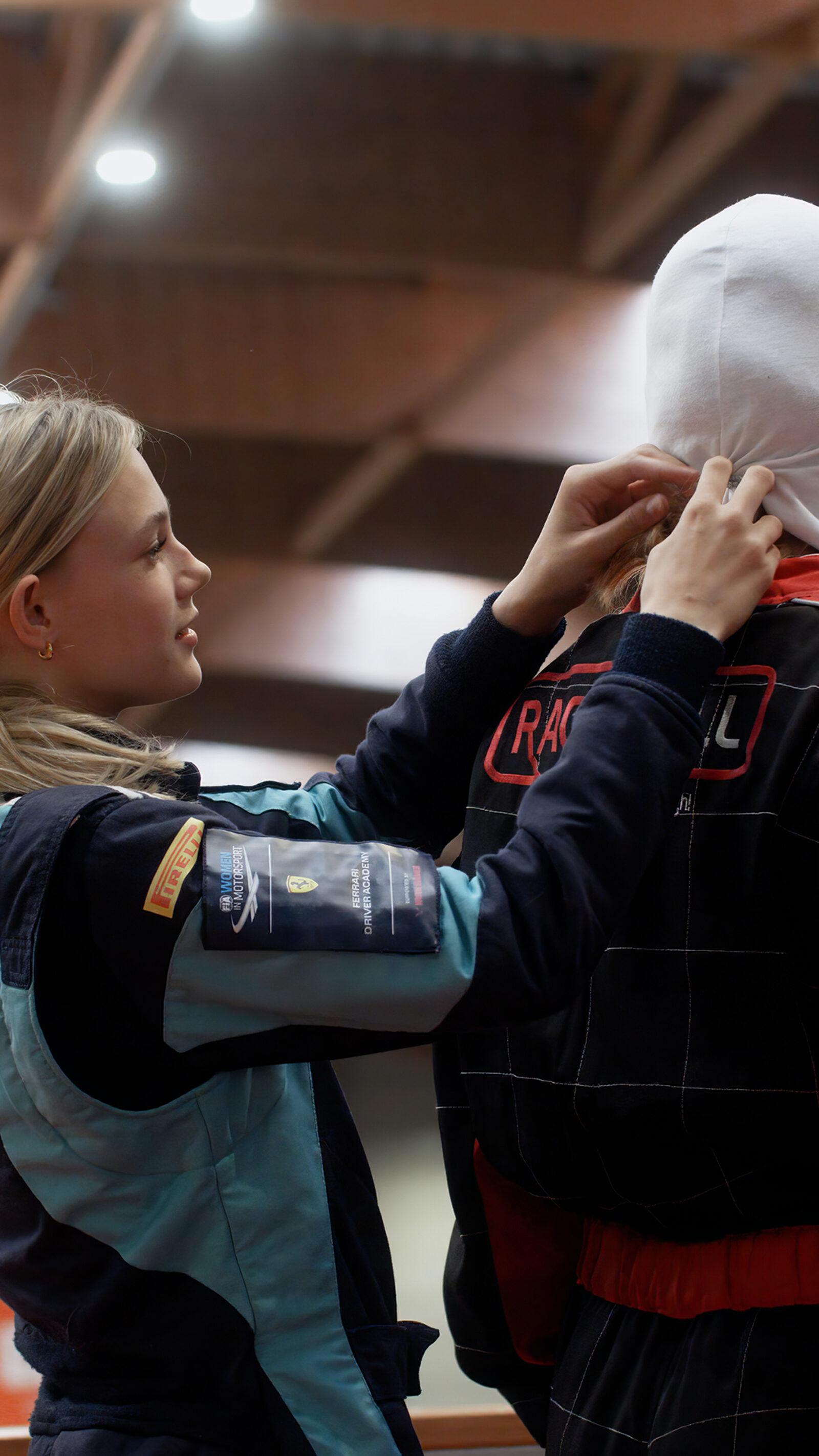 A GIRL helping another with her helmet